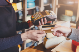 Debit card transaction Representative graphic of a customer doing a debit card transaction at a shop