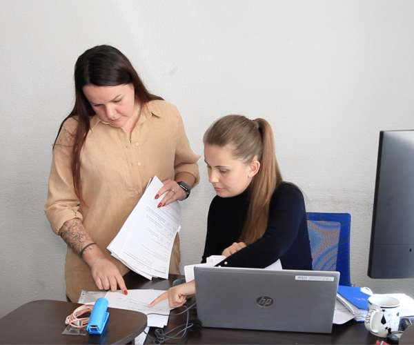 Client discussion Two clients discussing some paperwork in their office room